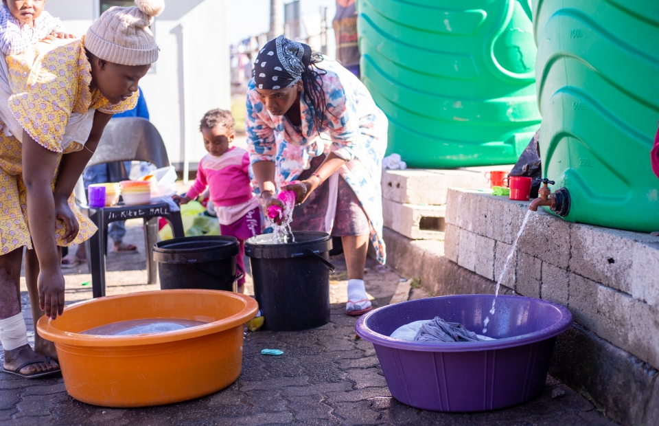 des femmes en afrique du sud prennent de l'eau dans un tonneau