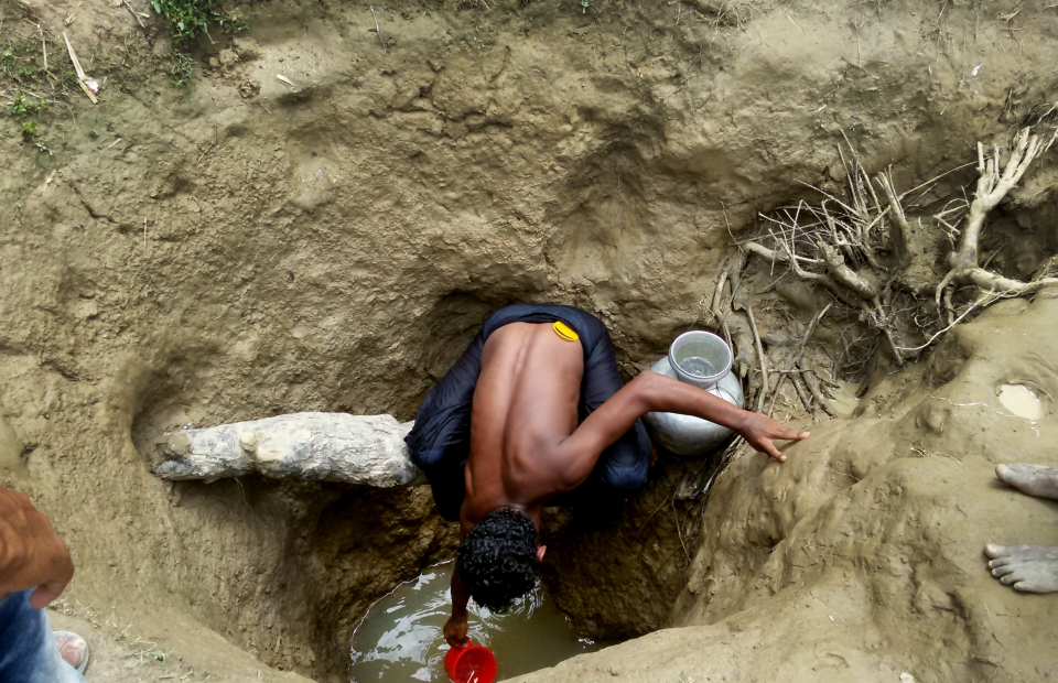 Un homme récupère l'eau d'un puits creusé à la main dans un camp de fortune d'Unchiparang. Même dans un puits de 3m de profondeur, l'eau n'est pas nécessairement potable. MSF reconstruit certains de ces puits pour les rendre plus propres et plus sûrs, et traite l'eau pour s'assurer qu'elle soit potable. © Paul Andrew Jabor/MSF