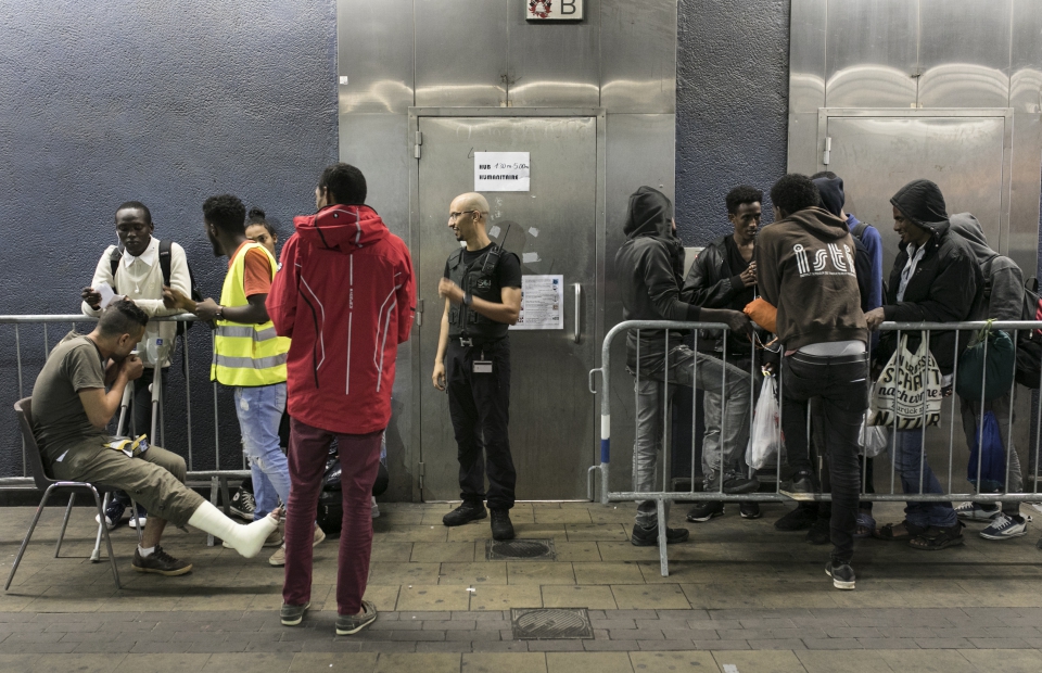 Migranten, vluchtelingen en asielzoekers wachten voor de ingang van de humanitaire hub voordat deze opent. © Albert Masias