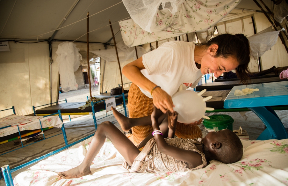 Nyamach joue avec son infirmière, Bárbara García, qui a transformé un gant chirurgical en ballon improvisé.  Soudan du Sud, avril 2019. © Igor Barbero/MSF