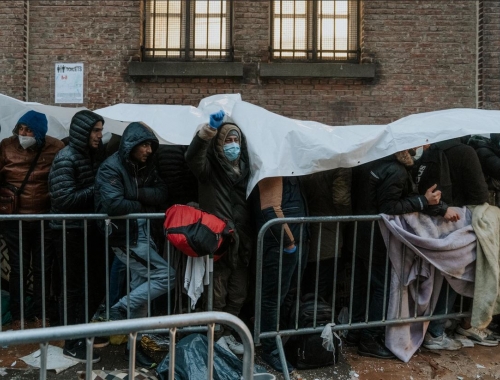 demandeurs d'asile attendent devant Petit Chateau pour acceuil
