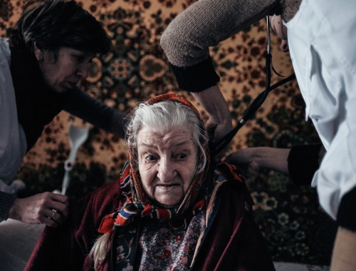 Het medische team van Artsen Zonder Grenzen helpt Pelagea Antonovna, 84 jaar, die in Marioepol in Oekraïne woont. © Misha Friedman