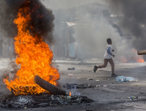 Een jongetje loopt weg in een gebarriceerde straat in Port-au-Prince