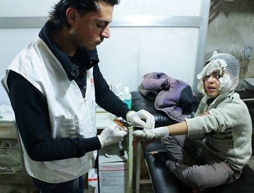 Un collaborateur MSF soigne un enfant syrien dans un camp de déplacés © MSF