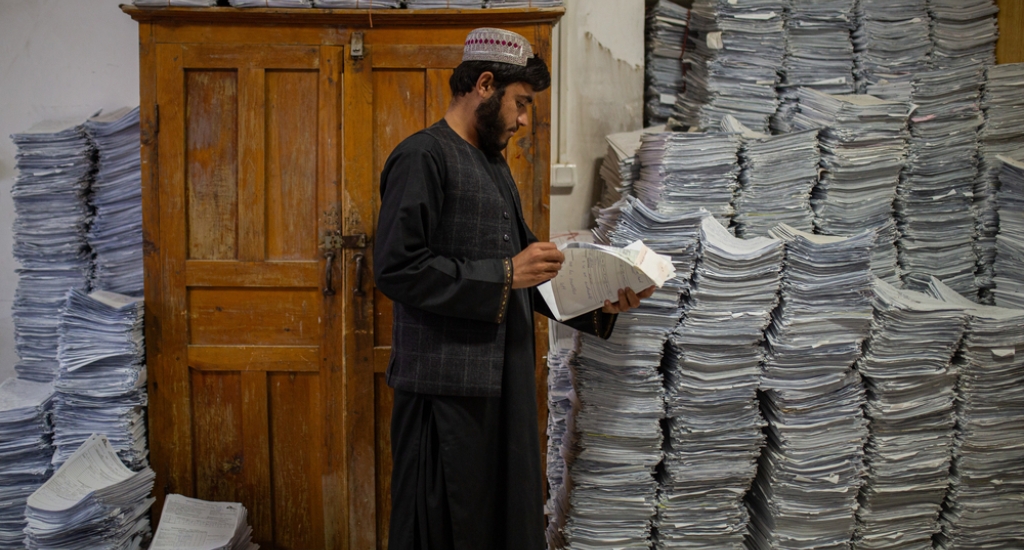 Een medewerker raadpleegt een patiëntendossier in een kamer vol medische gegevens en bestanden, op datum gesorteerd, in het door AZG gesteunde, provinciale ziekenhuis Boost. Lashkar Gah, Helmand, Afghanistan, september 2025.