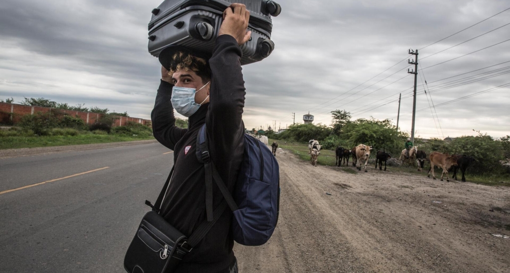Een jonge Venezolaanse migrant loopt over de Pan-Amerikaanse snelweg naar Tumbes, Peru, 