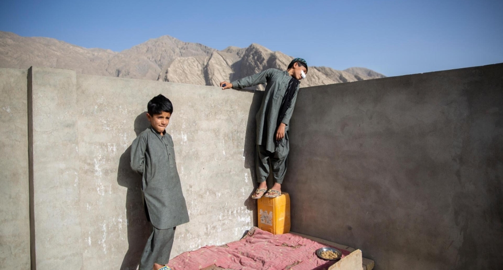 Idris (rechts) speelt met zijn jongere broer Mohammad (links) op het dak van hun huis in Quetta