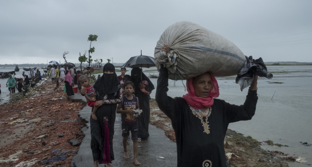 Des réfugiés marchant sous la pluie lors du passage de la frontière, à la rivière Naf.