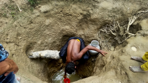 Een man haalt water uit een met de hand gegraven waterput in het kamp Unchiparang. Maar ook op drie meter diepte is water niet noodzakelijk drinkbaar. © Paul Andrew Jabor/AZG