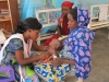 Een medewerkster van AZG verzorgt een kind dat vergezeld wordt door diens mama in Kameroen