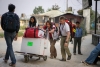 Een team van AZG rolt een bagagedrager met medische spullen binnen in de luchthaven van Kathmandu. ©Brian Sokol/Panos 
